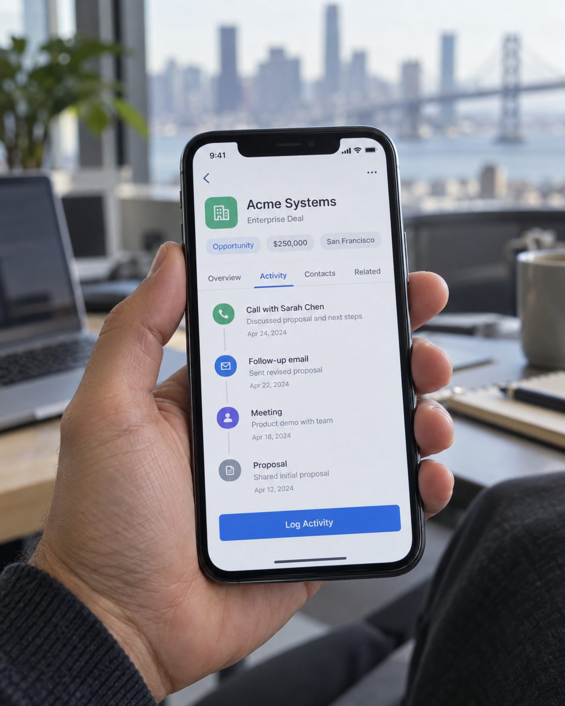 Sales rep holding a phone with a deal record open in the CRM app
